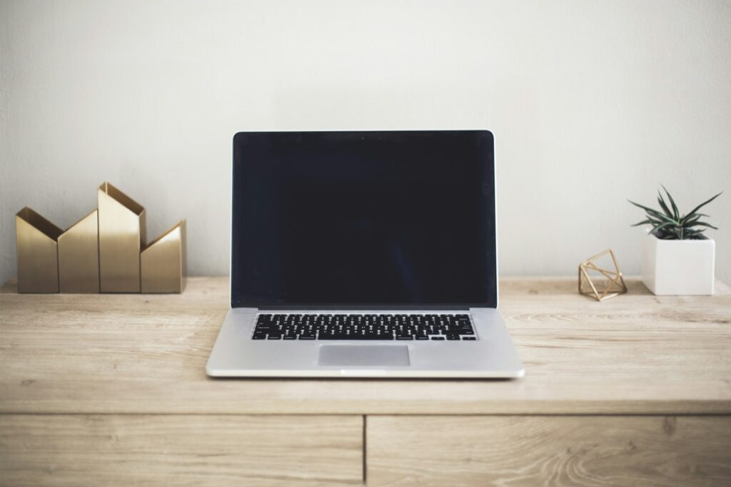 Laptop on desk with keyboard and coffee for buying guide
